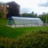 40 Space Original Enclosure installed in a grassy field outside of an apartment block