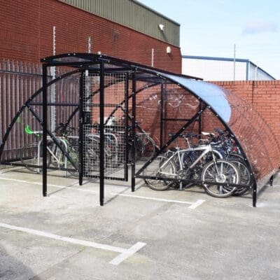 20 Space Original Enclosure with black powder-coated steel frameworks stored outside next to a brick building, with several bikes being stored
