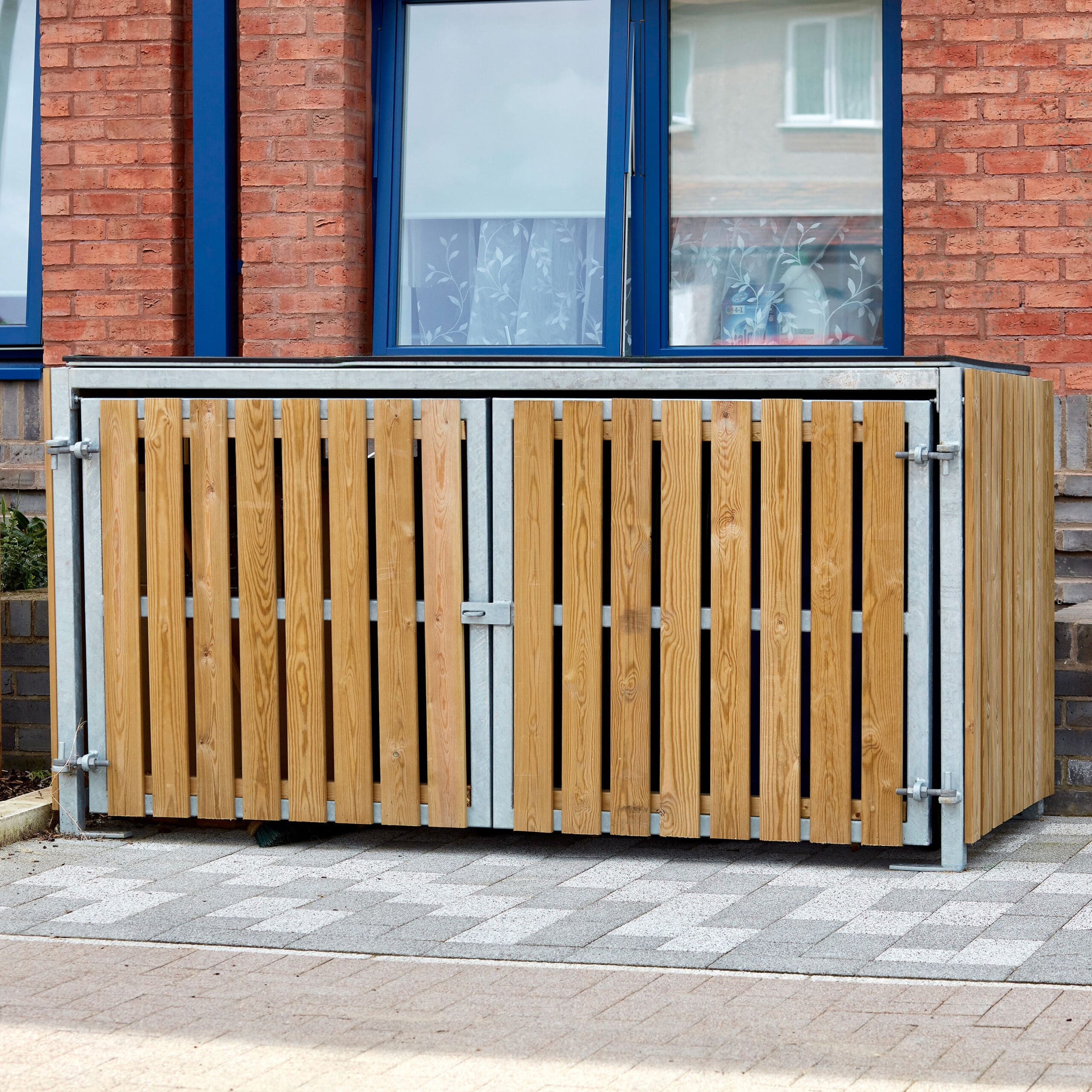 close up shot of the Amazon Eco 2 Cycle Locker installed out of a newly built brick apartment complex where the locker is sitting directly outside