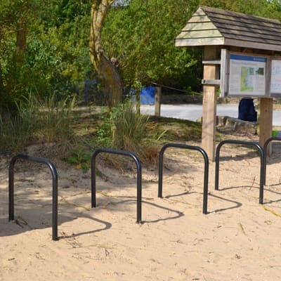 Sheffield Cycle Stand in Galvanised Black installed by a body of water on the sand