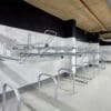 row of Two Tier Cycle Racks inside of a commercial building with sheffield stands underneath