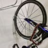 Vertical Bike Rack on a white wall with a bike securely stored in them