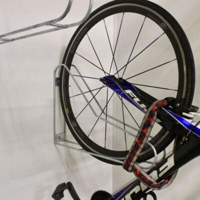 Vertical Bike Rack on a white wall with a bike securely stored in them