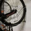 Close up shot of Vertical Bike Rack on a white wall with a bike securely stored in them