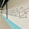 Vertical Bike Rack installed on a white brick wall in an underground bike storage facility with a bike hanging securely in the distance