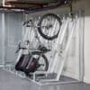 Semi Vertical Bike Rack installed in an underground cycle storage facility next to Perforated Mesh Fencing and bike being stored semi-vertically