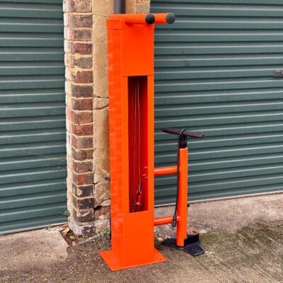 Public Maintenance Bike Stand in RAL colour orange installed outside of a commercial property with a bike pump and various bike repair tools