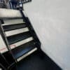Small Bike Stair Ramp installed on a set of black metal stairs outside a residential property