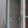 close up of a wooden bike shelter mesh wall