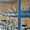 Modern indoor bicycle parking facility with empty racks and a few parked bicycles, featuring wooden panel walls and a clear focus on orderly, secure storage.