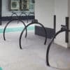 A row of jet-black powder coated Equilibrium Cycle Stands installed in an underground cycle shelter with more around the corner in the background