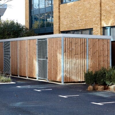 Semi Vertical Amazon Eco Shelter with timber cladding and grey fascia installed outside a commercial building