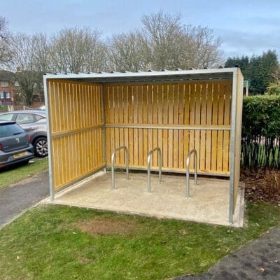 wooden cycle shelter with sheffield stands outside a property