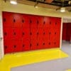 Islington Locker installed in a cycle storage end of trip facility, with red doors and black locks, on top of a yellow floor.