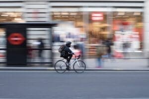 person riding there bike through a busy commercial street 