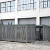 metal bike shelter with bikes stored in stands outside of an office building