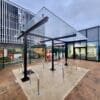 a glass roof bike rack with metal bars in front of a building
