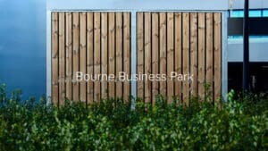 bespoke premium wooden bike shelter outside behind a shrub