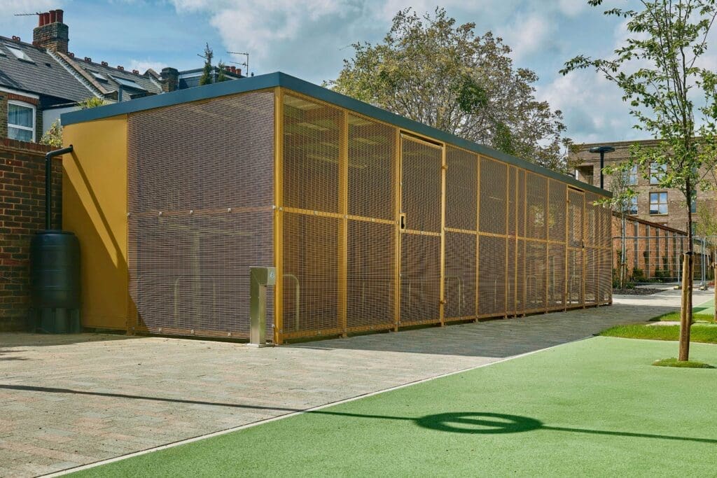 Yellow mesh cycle enclosure installed outside of a residential property in a recreational community area