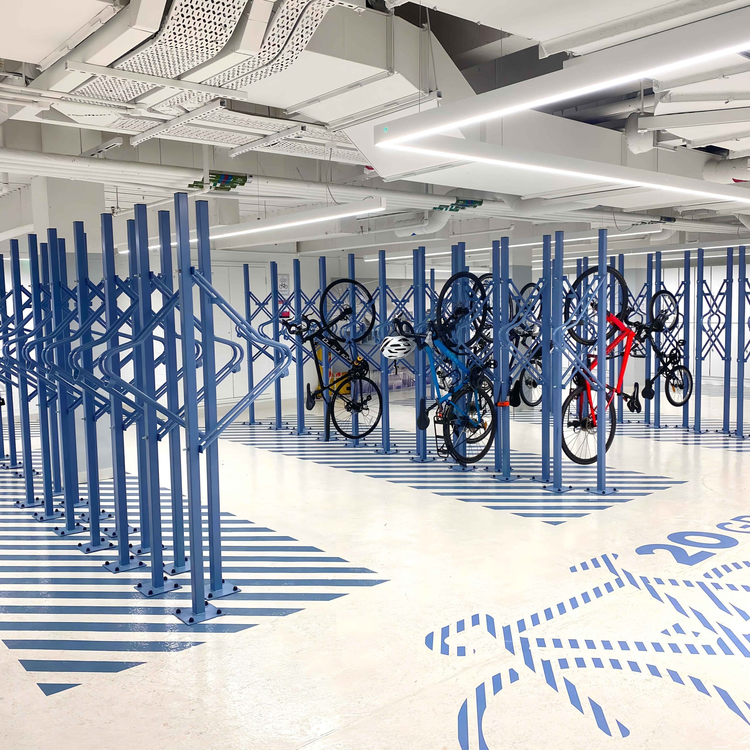 Premium Solo Vertical Bike Racks installed in an underground cycle storage facility in RAL colour blue