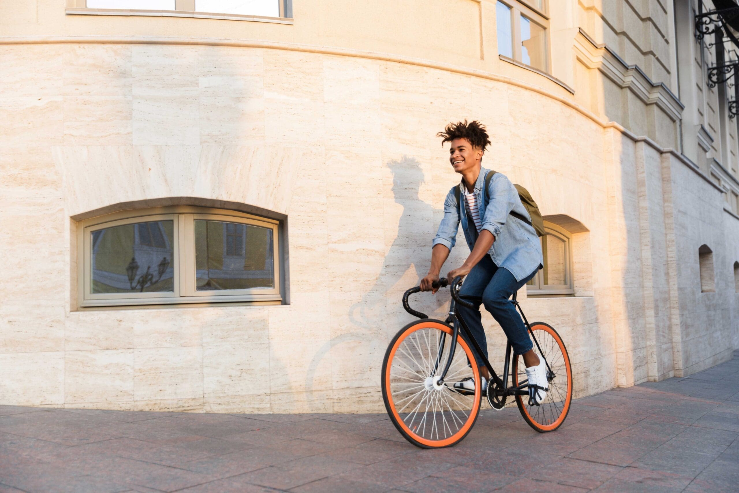Cyclist riding his bike through the city streets with a backpack on