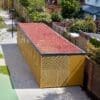 Metal and perforated mesh cycle shelter with sedum roofing installed outside