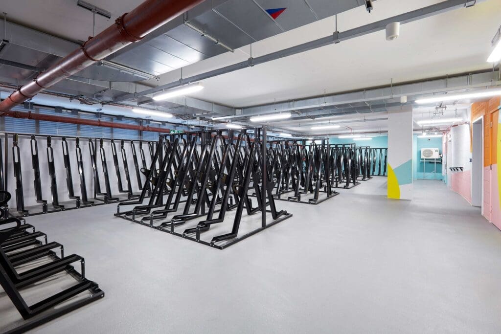Several rows of Semi Vertical Cycle Racks installed in an internal cycle storage facility