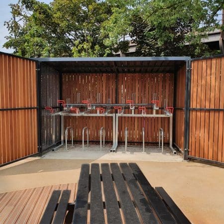 wooden cycle shelter with two tier cycle racks installed and swing doors