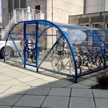 20 space original enclosure with blue metal framing and mesh door installed outside a residence with bikes parked