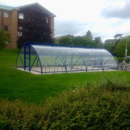 40 Space Original Enclosure installed in a grassy field outside of an apartment block