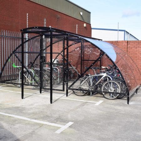 20 Space Original Enclosure with black powder-coated steel frameworks stored outside next to a brick building, with several bikes being stored