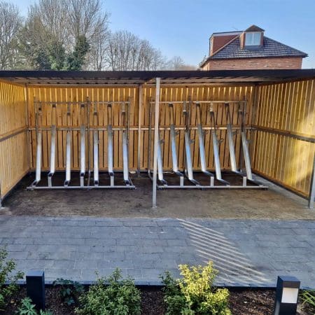 semi vertical bike racks installed in a wooden bike shelter