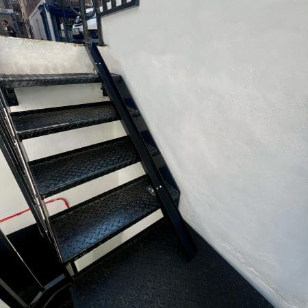 Small Bike Stair Ramp installed on a set of black metal stairs outside a residential property