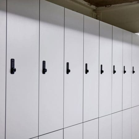 A row of Camden Clothing Lockers with white laminate doors and Digi Code Lock installed in an underground bike storage facility.
