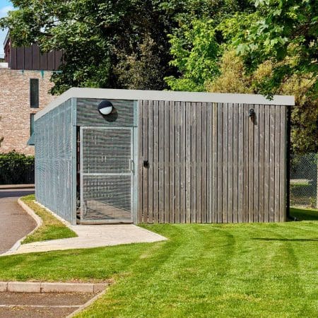 a large wooden bike shelter on a lawn