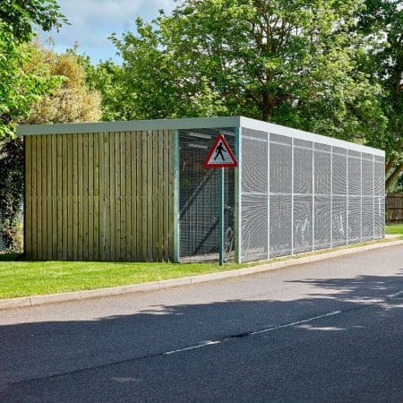 a large wooden cycle shelter with metal fencing on a lawn