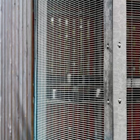 close up of a wooden bike shelter mesh wall