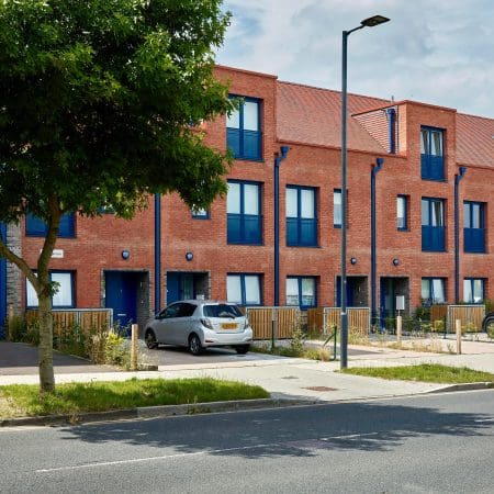 Newly built apartment blocks in a London suburb with the Amazon Eco 2 Cycle Locker installed outside the front of each apartment
