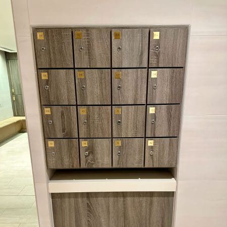 Islington Locker with wood panelling and gold accents installed in an end of trip cycle storage facility