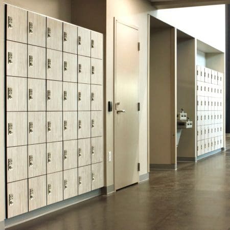 Render of white Islington Lockers installed in a hall way with gold accents