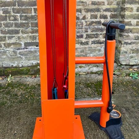 Public Maintenance Bike Stand in RAL colour orange installed outside of a commercial property with a bike pump and various bike repair tools