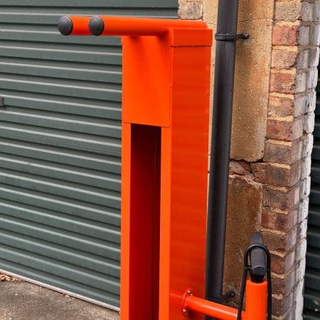 Public Maintenance Bike Stand in RAL colour orange installed outside of a commercial property with a bike pump and various bike repair tools