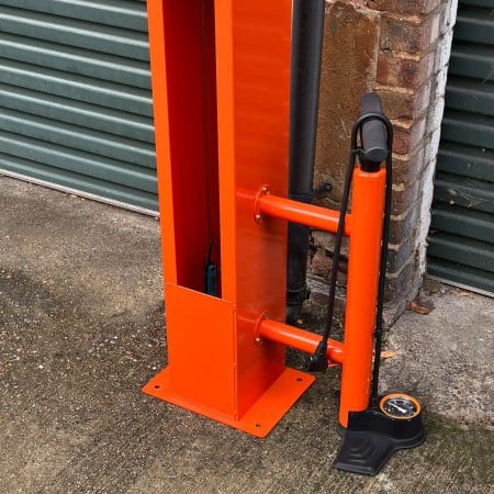 Public Maintenance Bike Stand in RAL colour orange installed outside of a commercial property with a bike pump and various bike repair tools