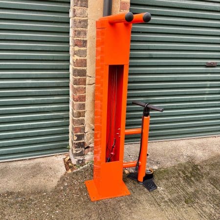 Public Maintenance Bike Stand in RAL colour orange installed outside of a commercial property with a bike pump and various bike repair tools