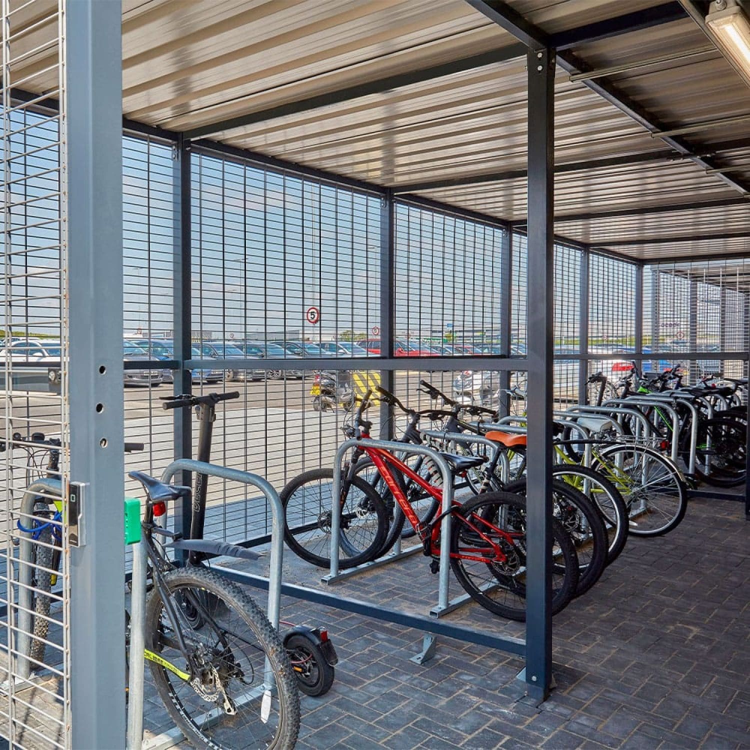 a group of bicycles parked in a covered metal bike storage facility