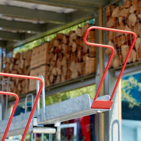 Close up of Two Tier Rack EasyGrip Handles in RAL Red, with habitat panelling installed behind