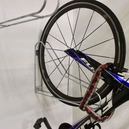 Vertical Bike Rack on a white wall with a bike securely stored in them