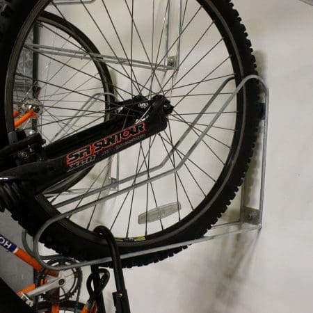 Close up shot of Vertical Bike Rack on a white wall with a bike securely stored in them