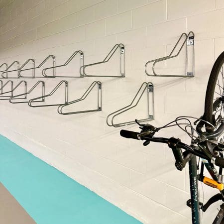 Vertical Bike Rack installed on a white brick wall in an underground bike storage facility