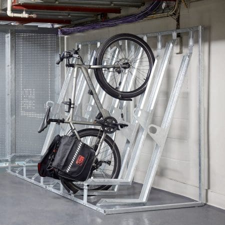 Semi Vertical Bike Rack installed in an underground cycle storage facility next to Perforated Mesh Fencing and bike being stored semi-vertically